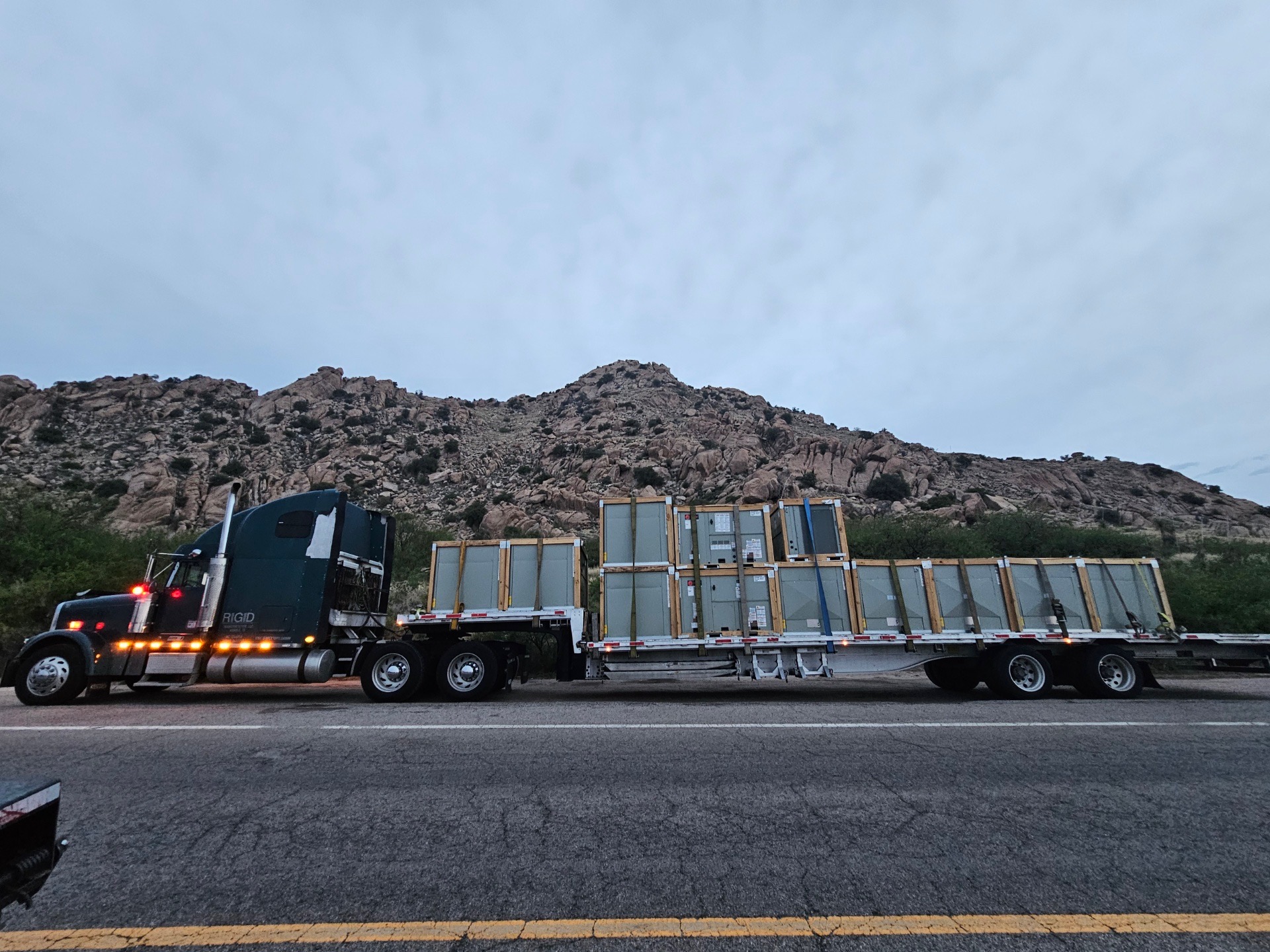RIGID flatbed hauling freight through a mountain roadway
