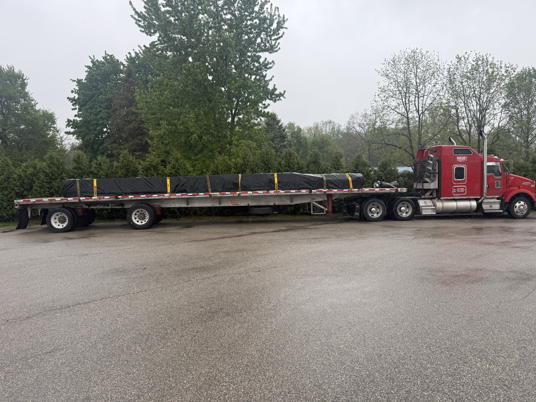 RIGID red flatbed truck hauling a tarped load